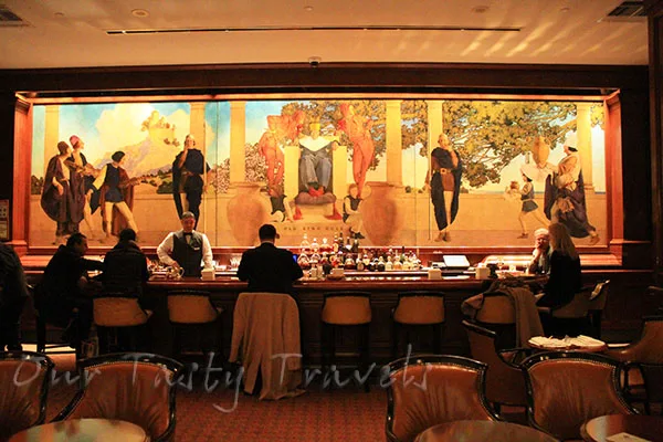 Giant mural is backdrop of bar at King Cole Bar at the St. Regis https://ourtastytravels.com/blog/st-regis-hotel-new-york-city-american-birthplace-of-the-bloody-mary-cocktail/ #ourtastytravels